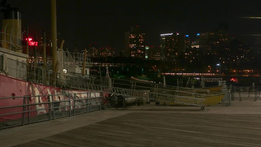 A dock with a bridge to a boat is being filmed