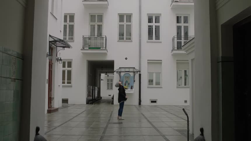 Woman walking through a courtyard of some buildings