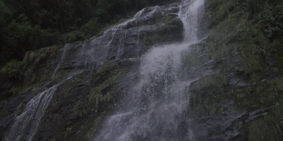 Waterfall seen from the ground cascading down a precipice