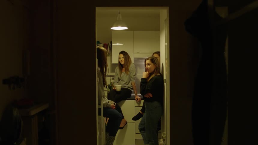 A group of women gather in the kitchen