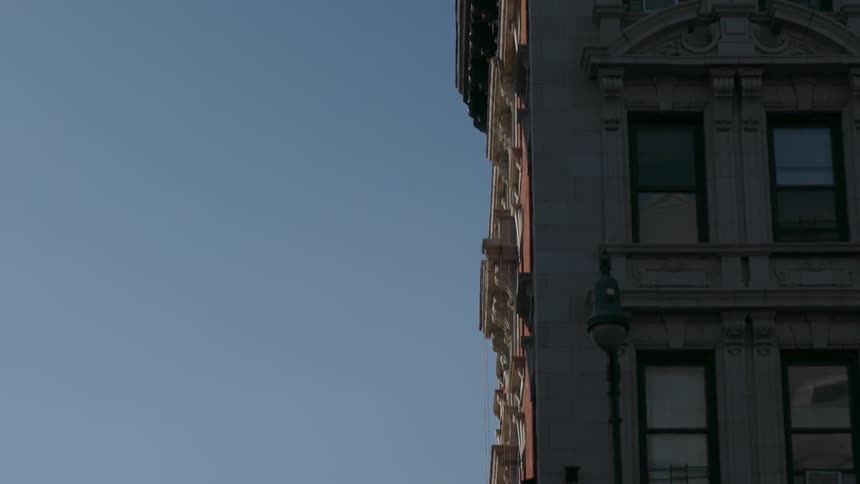 An apartment building stands against a blue sky