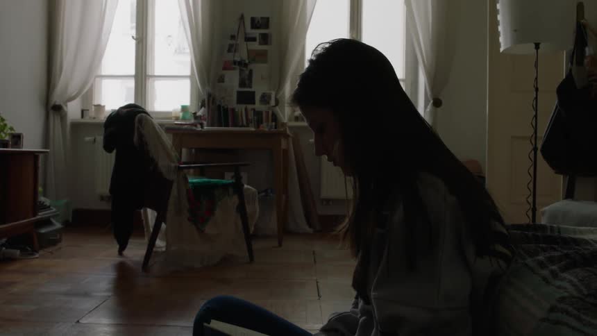 A woman is sitting down reading a book