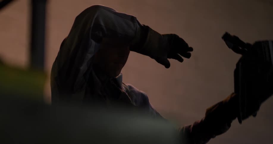 A welder removes his mask to wipe his brow