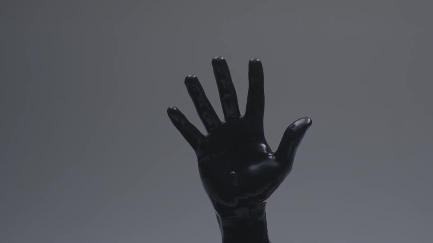 Black hand reaching up in a grey area