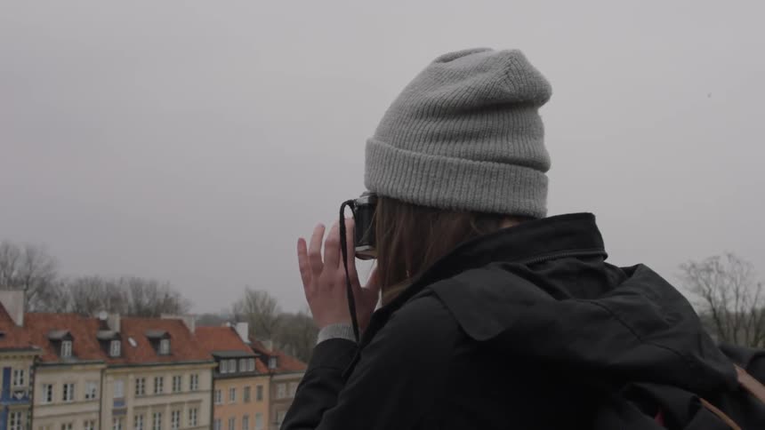 Woman takes pictures of a row of buildings