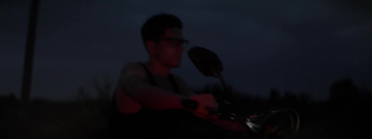 A man rides a motorcycle at night