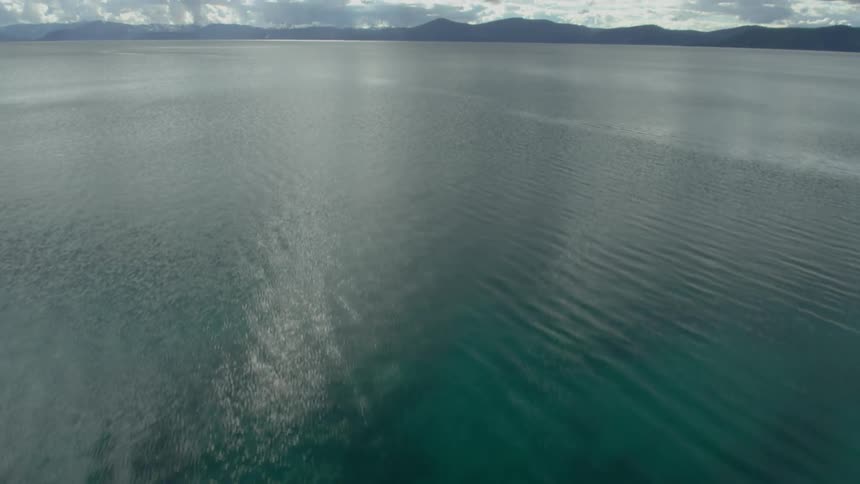 The water is clear with many rocks below