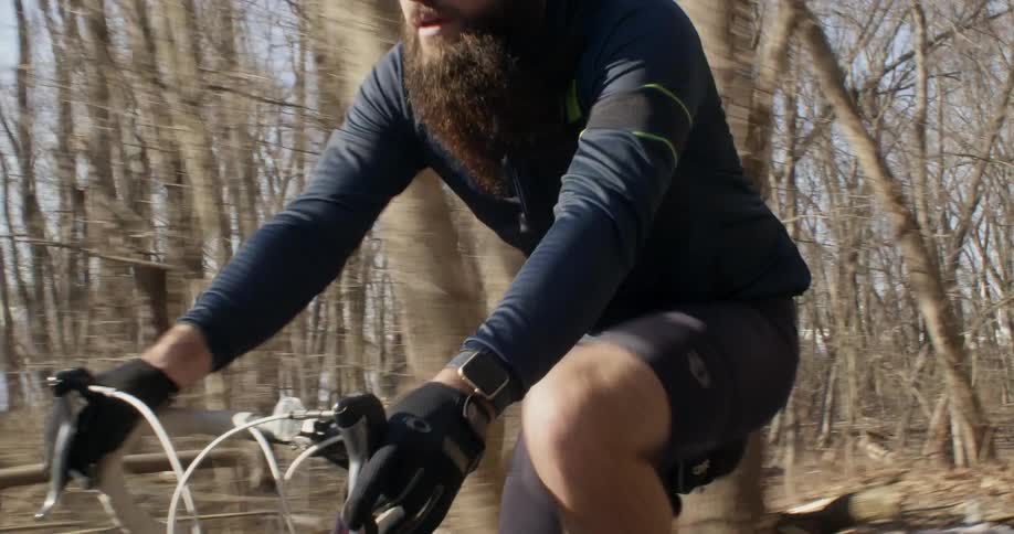 A bicyclist pedals next to a lake