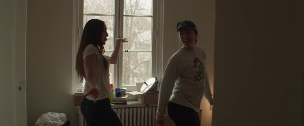 Two women dancing in a new apartment