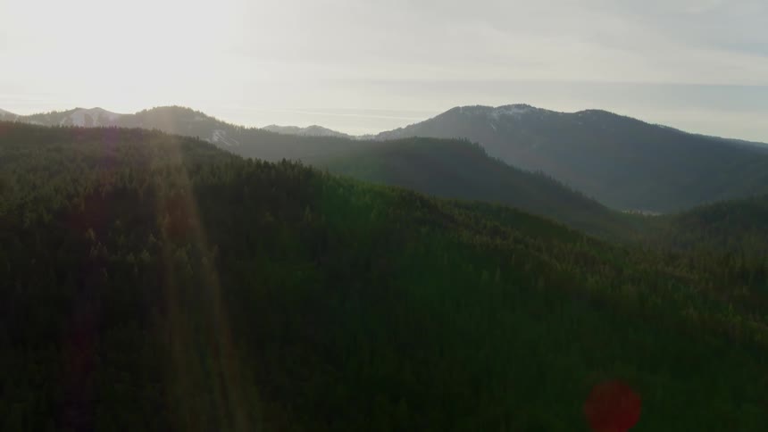 Tree covered mountains sit under a cloudy sky
