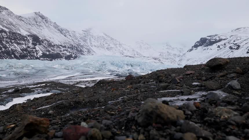 View of rocky land and snowy mountains