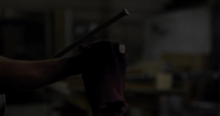 A man stains two pieces of wood with a rag