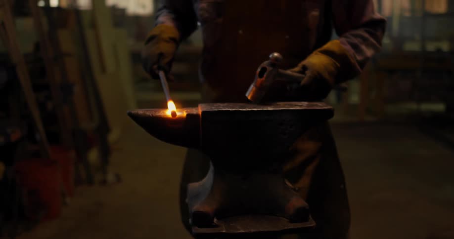Man using a hammer and anvil to shape hot metal