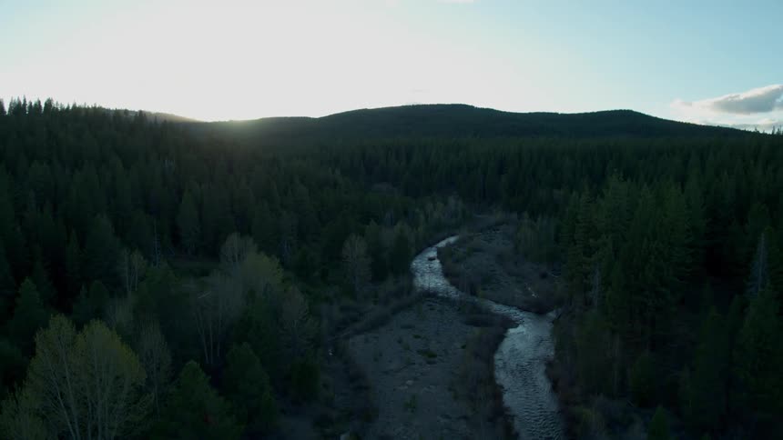 Water flows gently down a stream at sunset as camera drifts away