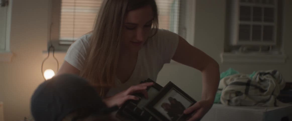 Women unpack a box with books and photo frames