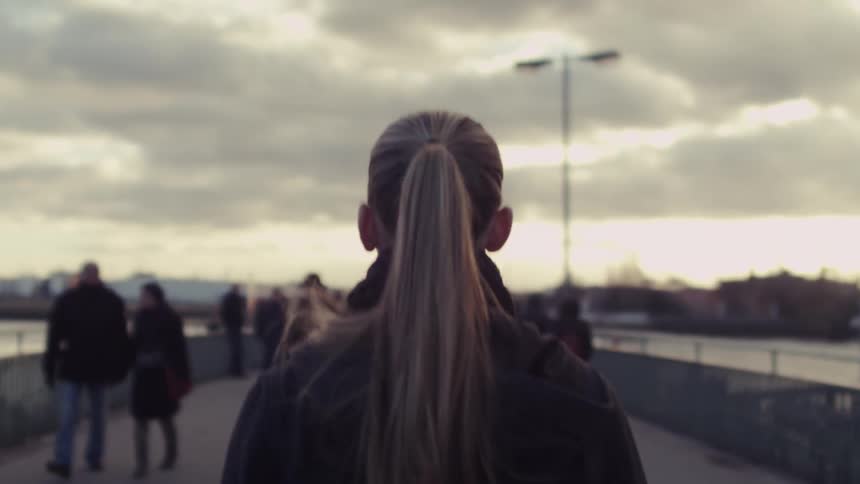 A woman walks down a busy sidewalk