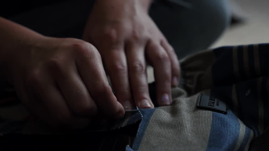 A person is threading some clothes
