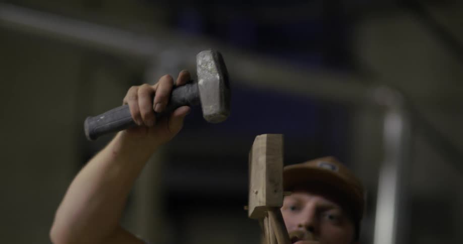 A woodworker hammers wood into place