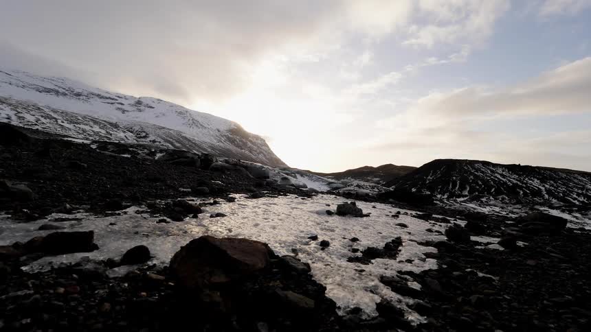 Clouds float over snowy mountains