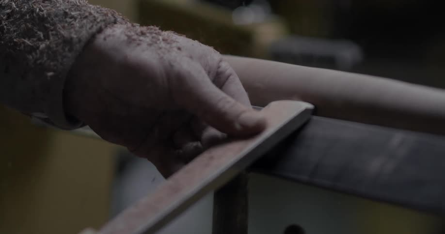 Man using tools to shave a piece of spinning wood