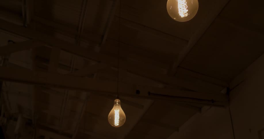 Light bulbs hanging in a row turning on at night
