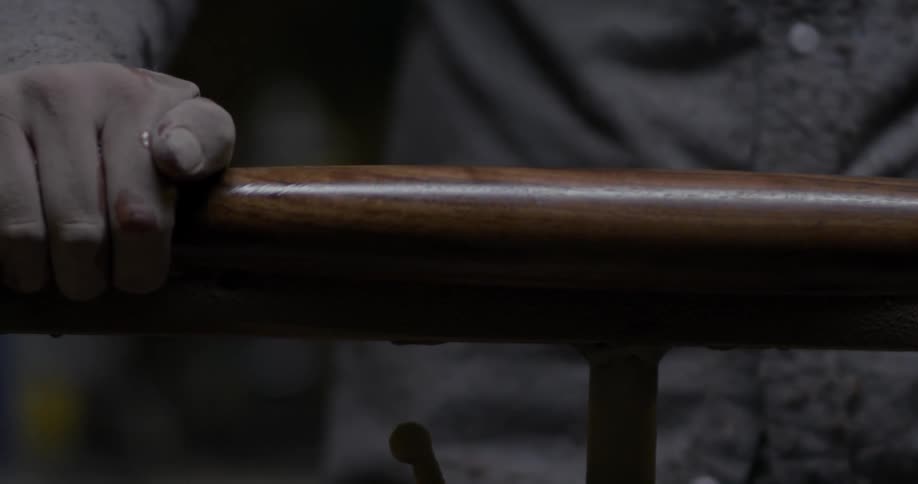Man inspecting a long round piece of spinning wood with his hand