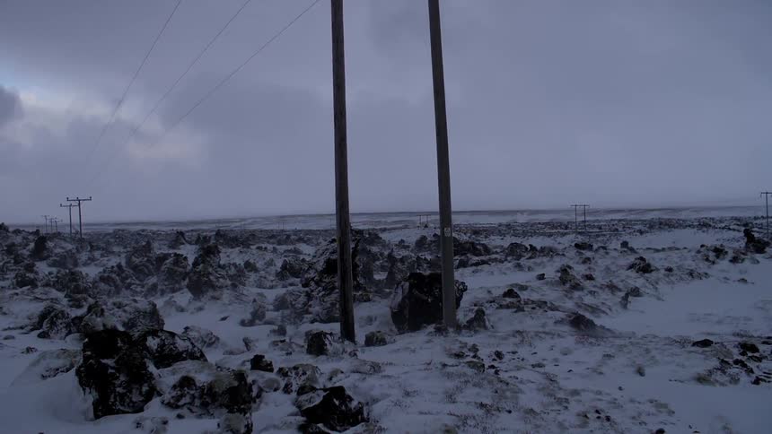 Power lines through a rocky snowy area