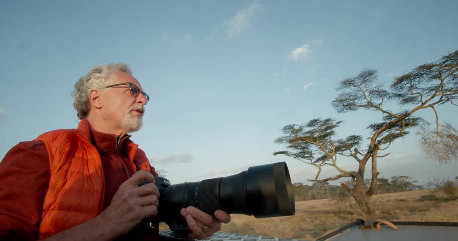 A man is riding on a vehicle taking photographs