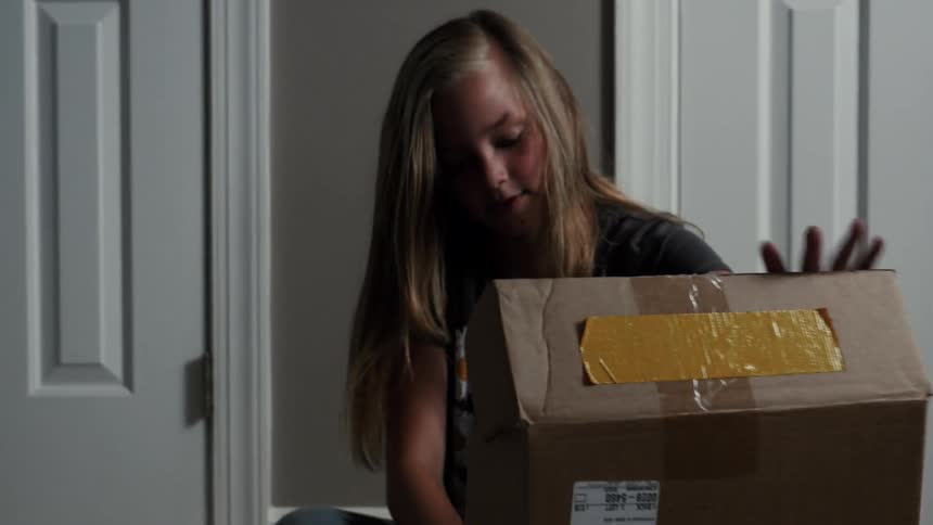 A blond girls opens a box