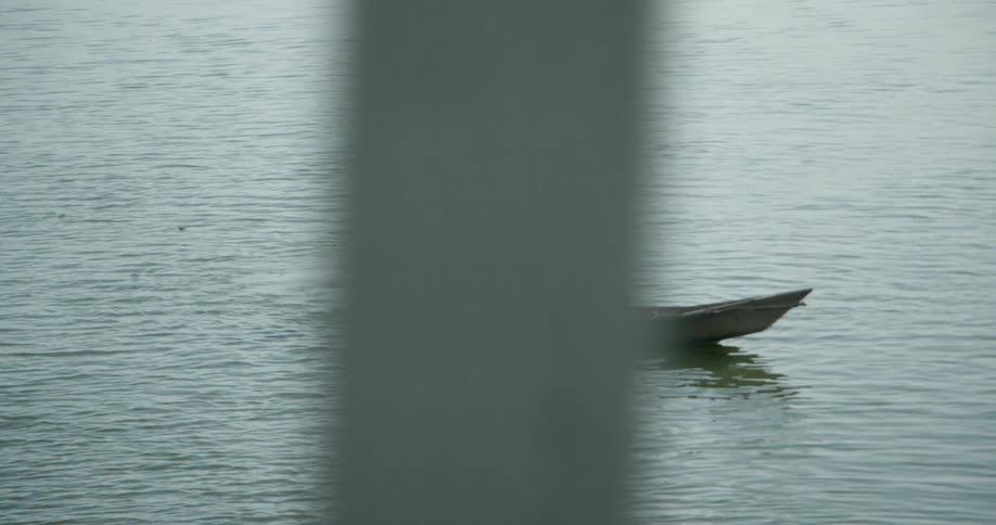 A man paddles a boat with two people in it