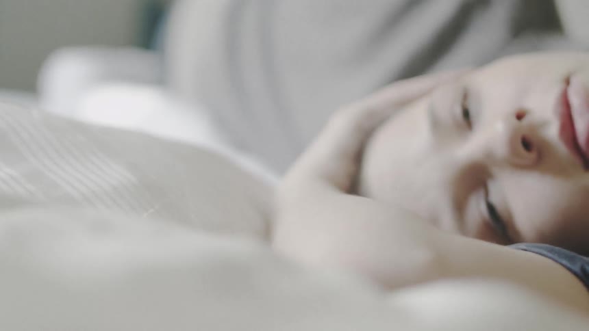 A woman lays in bed