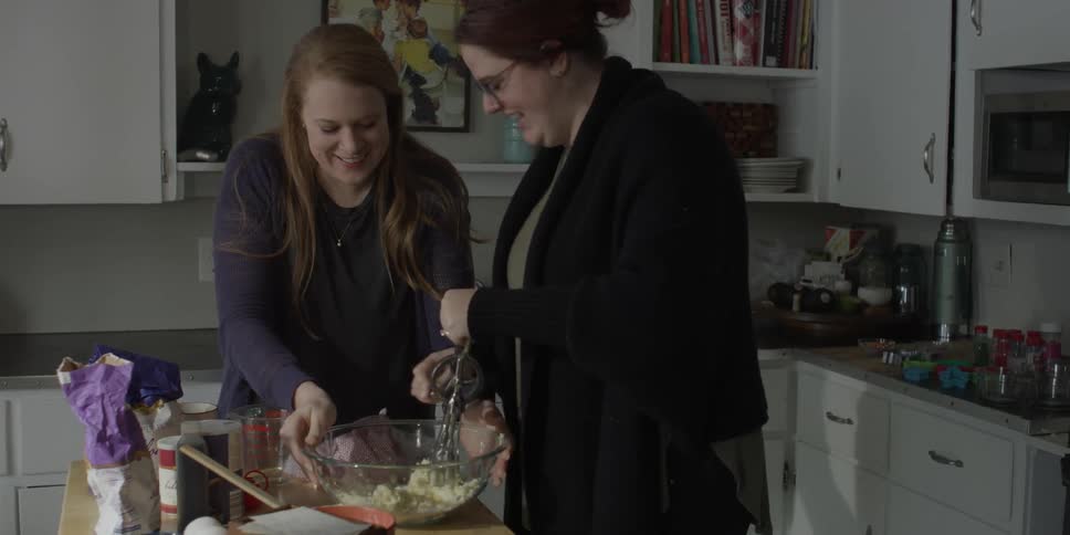 Two women are preparing food in the kitchen