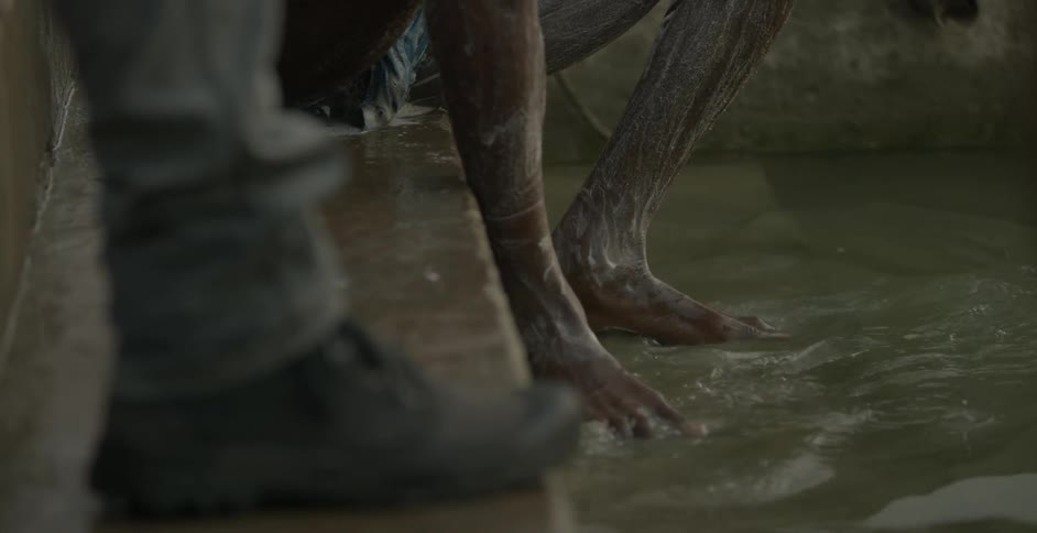 Man washes himself outside standing on steps