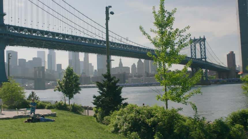 Two people jog down the trail by the bridge