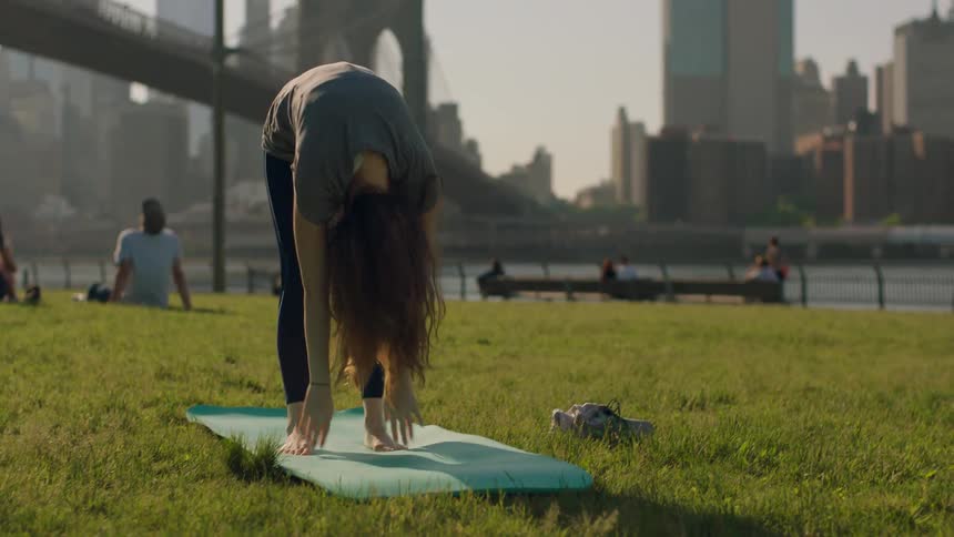 A woman does yoga in the park