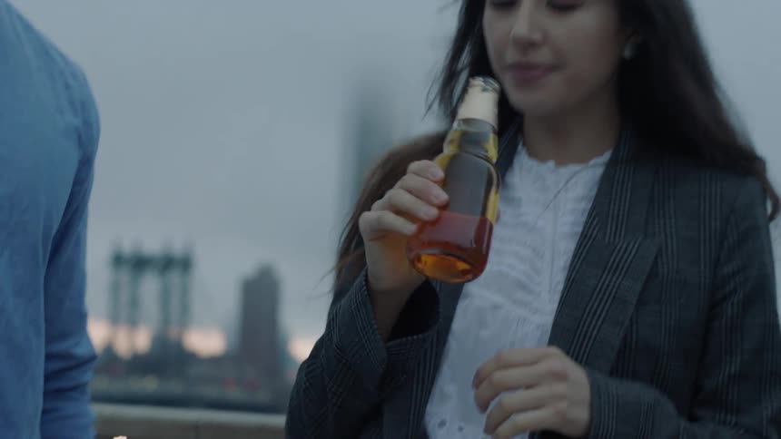 A man opens a bottle and hands it off