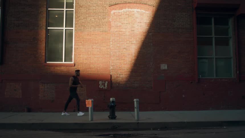 A male jogger stops then runs off again as he jogs