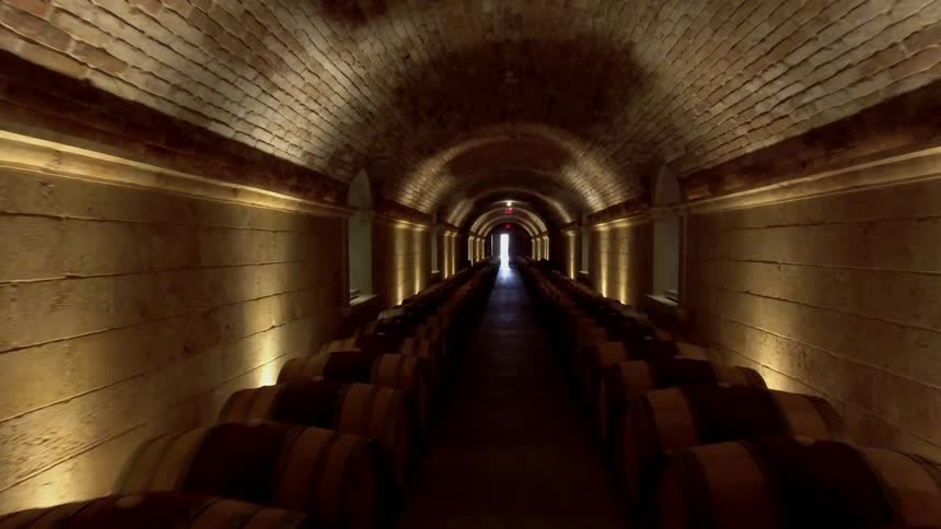 Barrels line a dim stone hallway