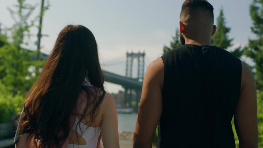 A man and woman gaze at a bridge ahead