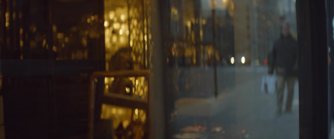 People walk by windows in front of shops