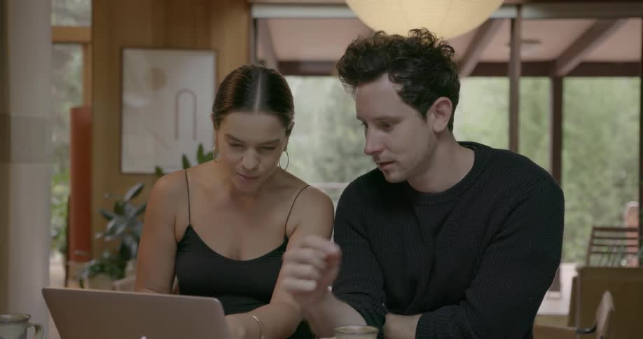 A man and woman work on a laptop