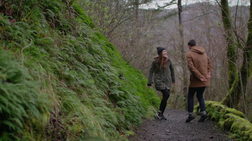 A man and woman dance on a forest trail