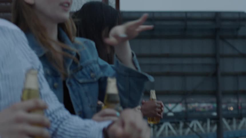 A group of young people drink on a patio