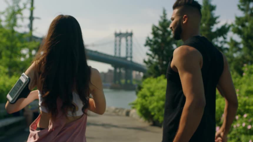 Man and woman stretch on a path in the park