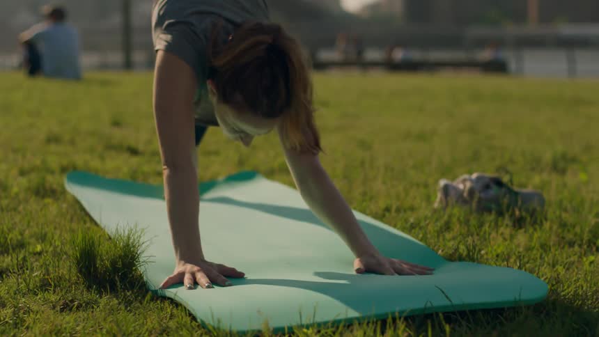 A woman is doing yoga on the grass
