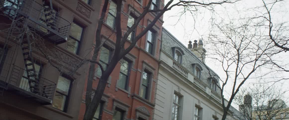 A fire escape hangs outside of an apartment building