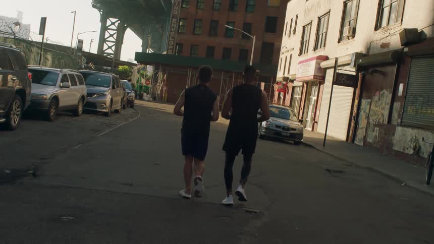 Two men jog down a city street