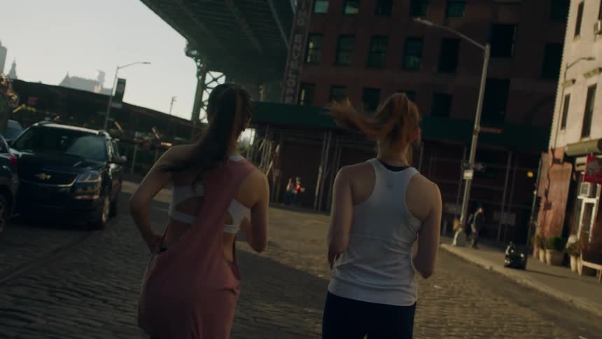 Two girls jogging in the city