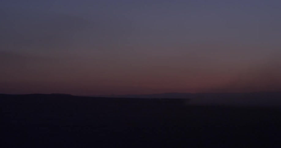 The sun is setting over the dark field