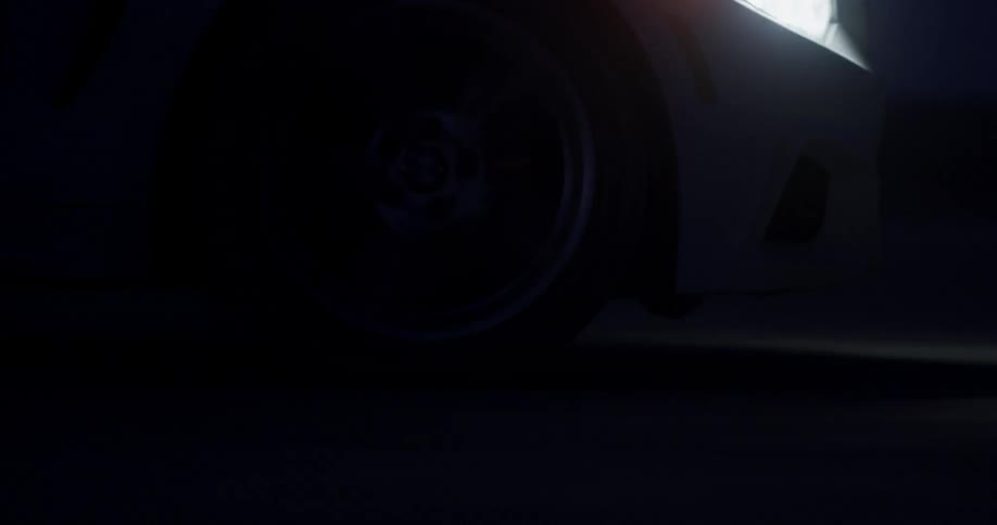 A car speeds down a road at night